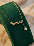 Elegant Gold-Toned "Smile" Script Necklace with Crystal Embellishments and Pearl Drop